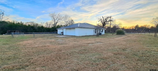 yard at dusk with an outbuilding and a garage