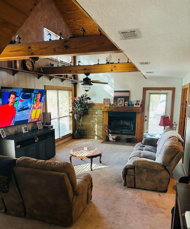 living room with ceiling fan, carpet, vaulted ceiling with beams, and a fireplace