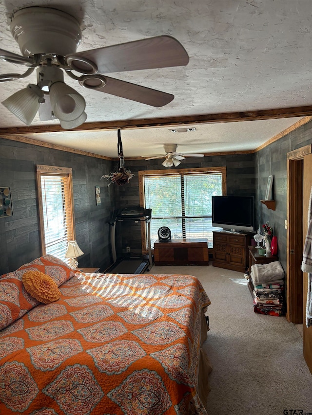 bedroom with wooden walls, ceiling fan, and carpet floors