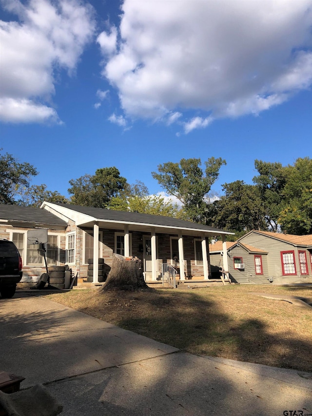 ranch-style house featuring a porch and a front yard