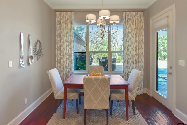 dining room featuring crown molding, wood-type flooring, and a notable chandelier