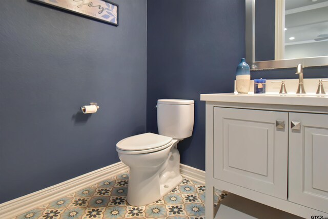 bathroom with tile patterned flooring, vanity, and toilet