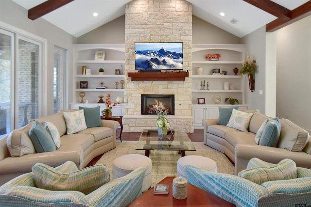 living room featuring vaulted ceiling with beams, a fireplace, light hardwood / wood-style floors, and built in shelves