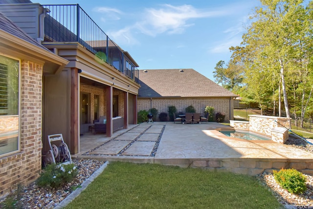 view of patio / terrace featuring a jacuzzi and a balcony