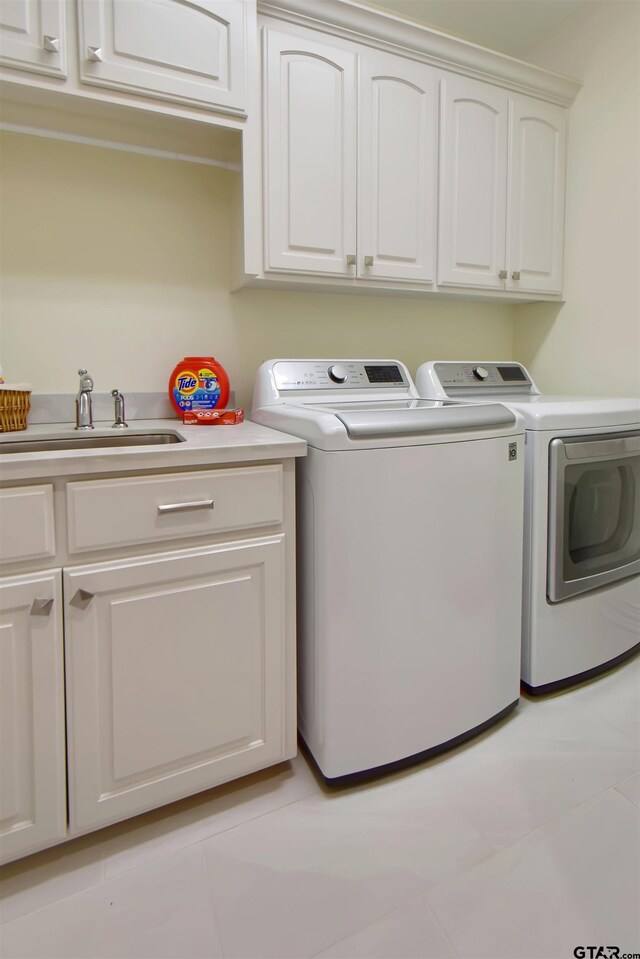 washroom featuring cabinets, light tile patterned floors, separate washer and dryer, and sink