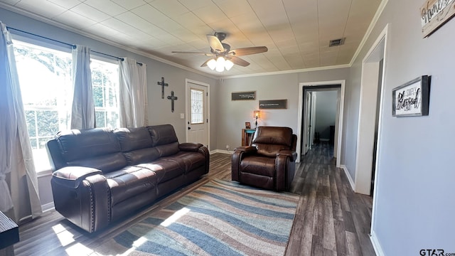 living room featuring dark hardwood / wood-style floors, crown molding, and ceiling fan