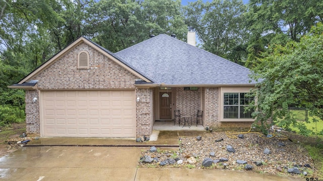 18313 Highmeadow Cir, Flint, TX 75762 - view of front of home with a shingled roof, brick siding, concrete driveway, an attached garage, and a chimney