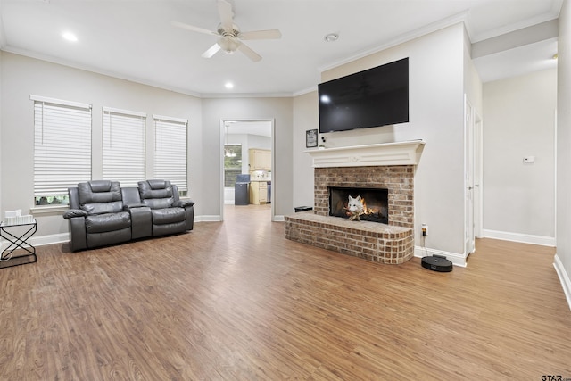 18313 Highmeadow Cir, Flint, TX 75762 - living area with a ceiling fan, wood finished floors, baseboards, crown molding, and a brick fireplace