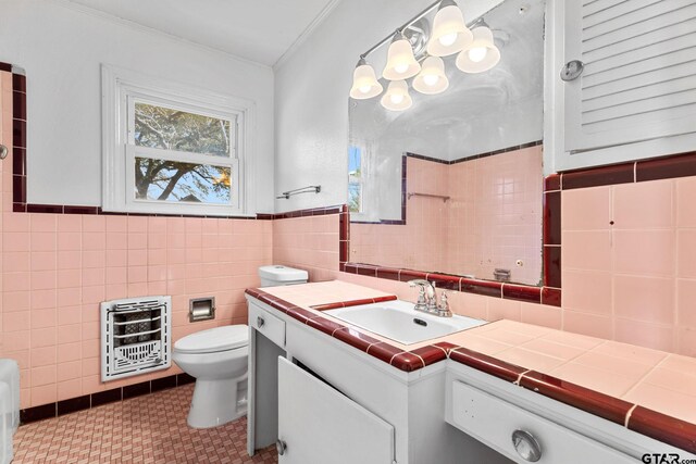 2444 Sunnybrook Dr, Tyler, TX 75701 - bathroom with crown molding, tile walls, heating unit, vanity, and toilet