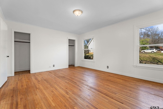 2444 Sunnybrook Dr, Tyler, TX 75701 - unfurnished bedroom with multiple windows, light hardwood / wood-style flooring, and multiple closets
