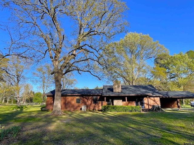 rear view of house with a yard and a carport