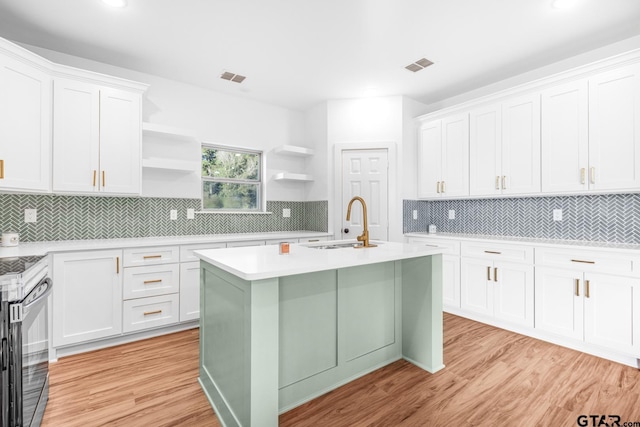 kitchen featuring visible vents, open shelves, electric range, a sink, and light countertops