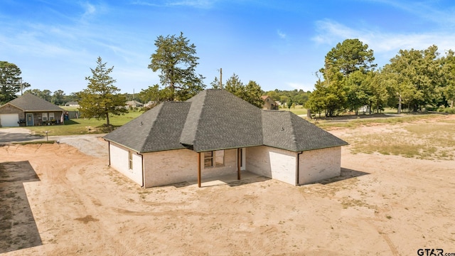 exterior space featuring driveway and roof with shingles