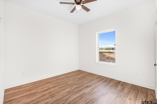 unfurnished room featuring ceiling fan, baseboards, and wood finished floors