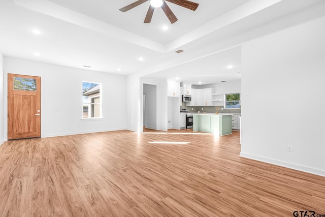 unfurnished living room featuring recessed lighting, light wood-type flooring, and baseboards