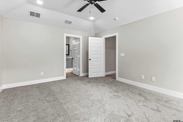 unfurnished bedroom with ensuite bath, carpet floors, ceiling fan, and vaulted ceiling