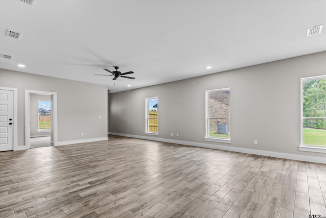 interior space featuring a wealth of natural light, ceiling fan, and light hardwood / wood-style flooring