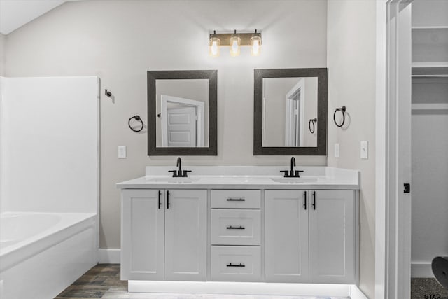 bathroom featuring hardwood / wood-style flooring, vanity, and a bathtub