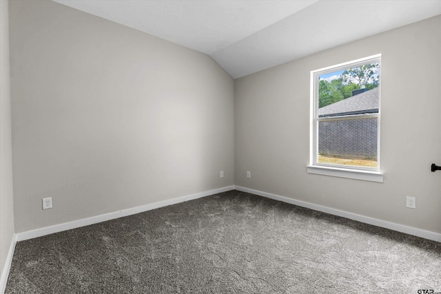 empty room featuring carpet and lofted ceiling