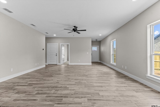 empty room with light wood-type flooring, plenty of natural light, and ceiling fan