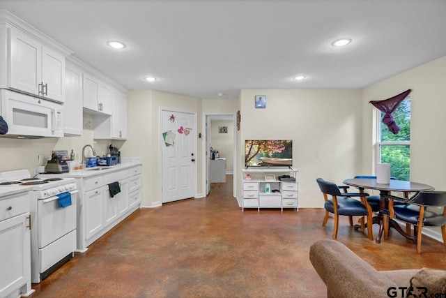 1131 E Commerce St, Tyler, TX 75702 - kitchen with white appliances, concrete floors, recessed lighting, light countertops, and white cabinetry