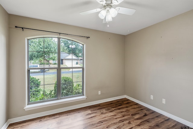 empty room with hardwood / wood-style floors, a healthy amount of sunlight, and ceiling fan