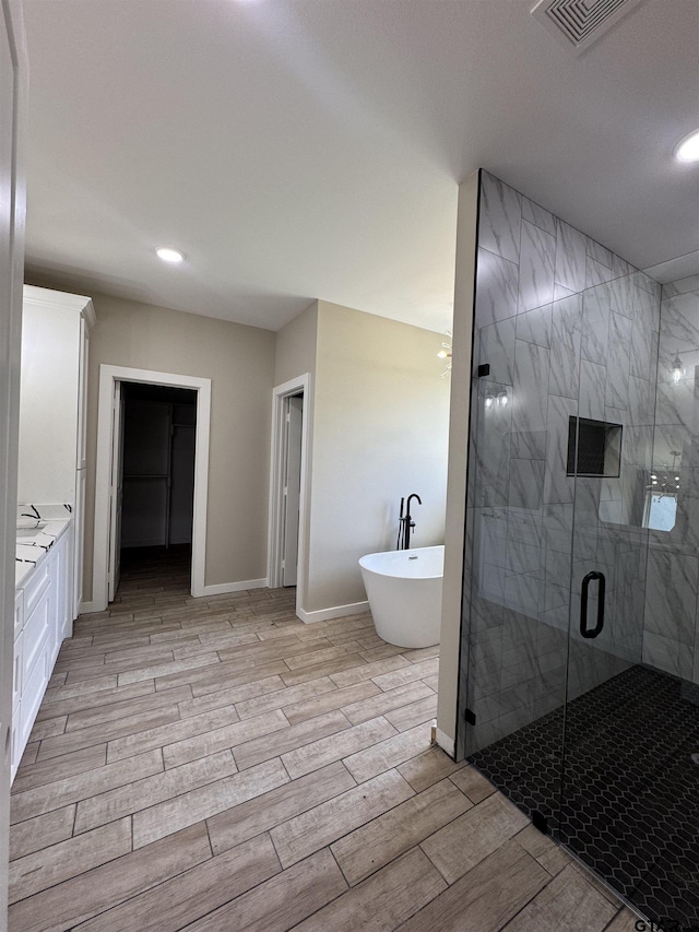 18268 US Jones Dr, Tyler, TX 75705 - full bath featuring a freestanding tub, wood tiled floors, a stall shower, vanity, and recessed lighting