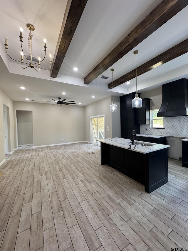 18268 US Jones Dr, Tyler, TX 75705 - kitchen featuring ventilation hood, dark cabinets, light wood-style floors, open floor plan, and recessed lighting