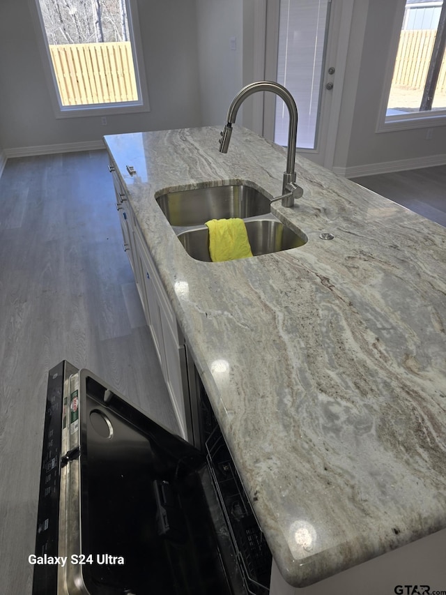 kitchen featuring light stone counters, sink, dark hardwood / wood-style flooring, and white cabinets