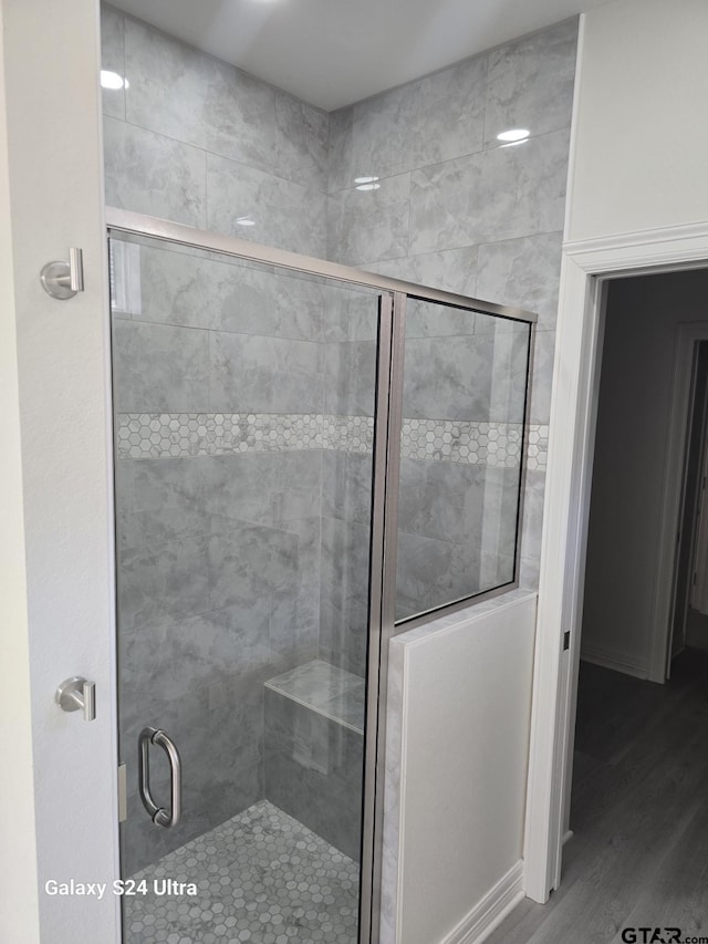 bathroom with wood-type flooring and walk in shower