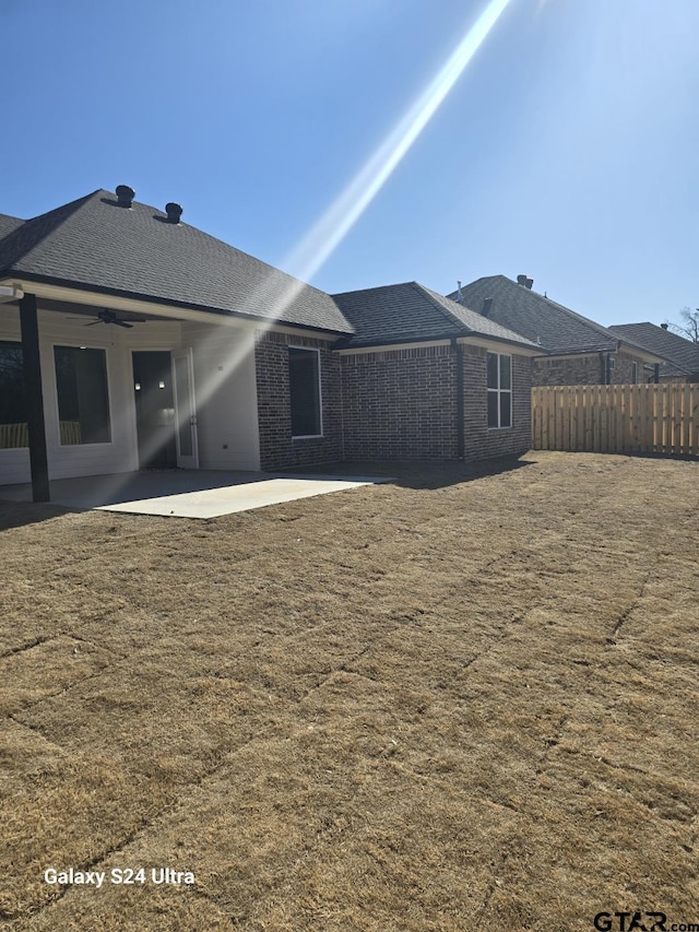 back of house featuring a lawn, ceiling fan, and a patio area