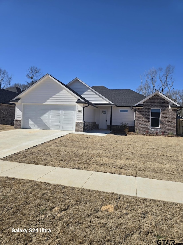 single story home with a garage and a front lawn