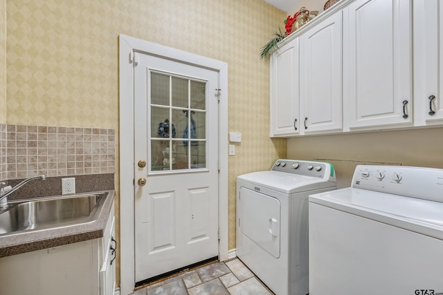 washroom featuring cabinets, sink, and washer and dryer