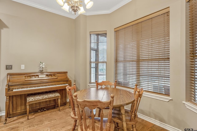 dining area featuring crown molding, light wood-type flooring, and an inviting chandelier