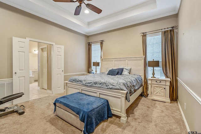 bedroom featuring a tray ceiling, ornamental molding, and light colored carpet