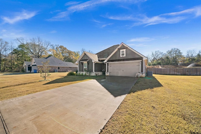 ranch-style house featuring central air condition unit, a front yard, and a garage