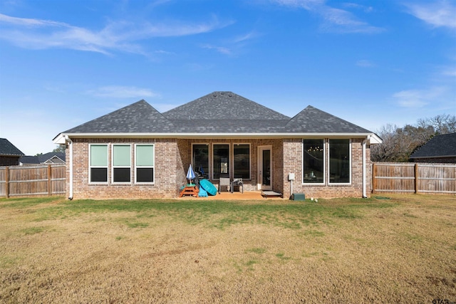 back of house featuring a lawn and a patio