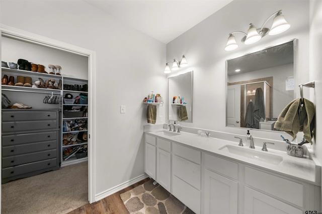 bathroom with wood-type flooring, vanity, and walk in shower