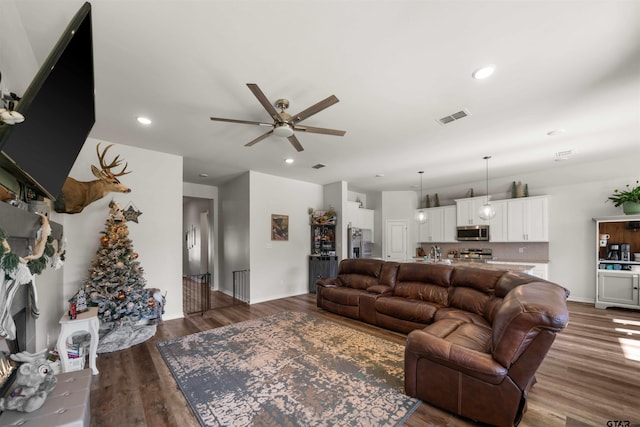 living room featuring ceiling fan and hardwood / wood-style flooring