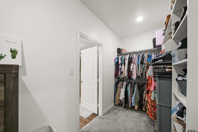 walk in closet featuring light carpet