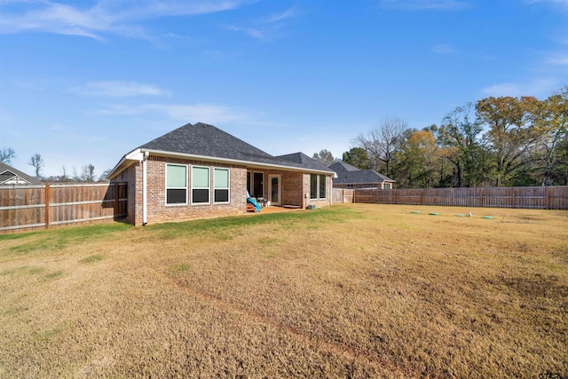 rear view of house featuring a yard