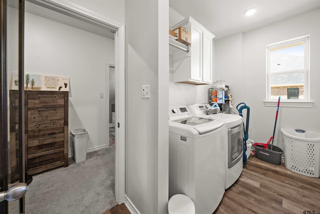 laundry area featuring cabinets, dark wood-type flooring, and washing machine and clothes dryer