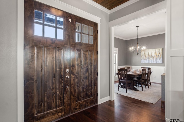 entrance foyer featuring dark hardwood / wood-style floors, an inviting chandelier, and ornamental molding