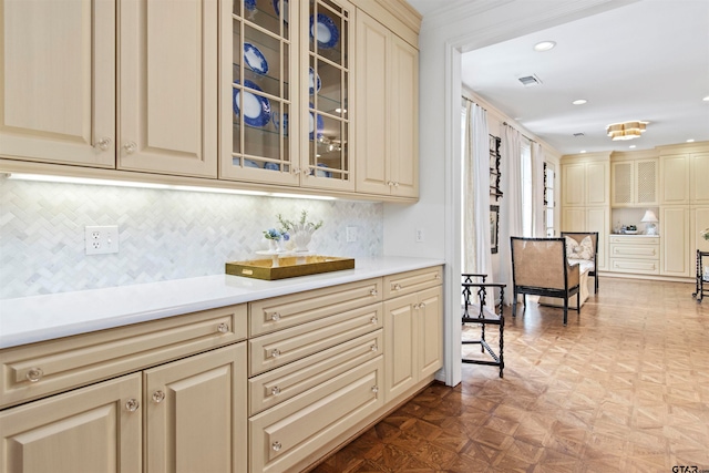 bar featuring parquet flooring, cream cabinetry, and decorative backsplash