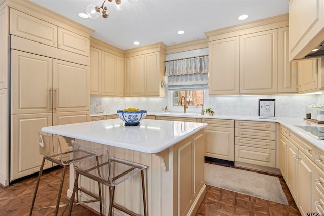 kitchen featuring sink, a breakfast bar, backsplash, dark parquet floors, and a center island