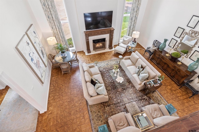 living room featuring a fireplace, parquet flooring, and a healthy amount of sunlight