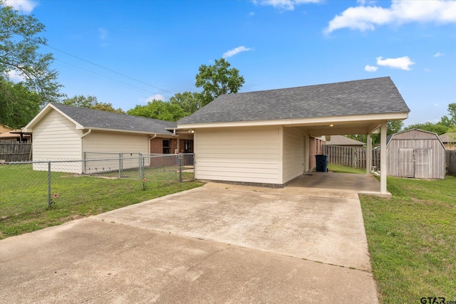 view of front of property featuring fence, a front lawn, concrete driveway, a shed, and an outbuilding