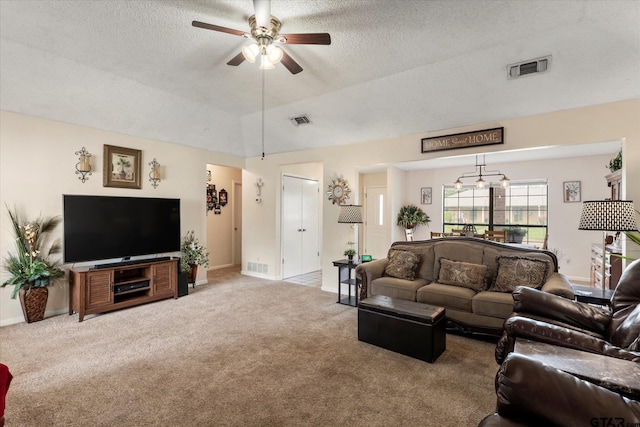 carpeted living area with ceiling fan, visible vents, and a textured ceiling