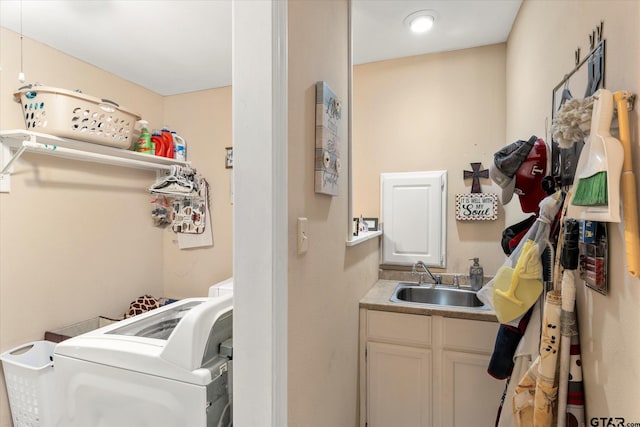 clothes washing area featuring cabinet space, washer / clothes dryer, and a sink