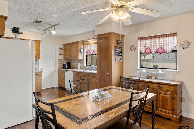 dining room featuring a ceiling fan, visible vents, a textured ceiling, and dark wood-type flooring